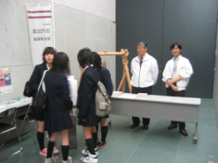 ラッキーナンバーを手にした学生はナンバーと記念缶バッチ交換
